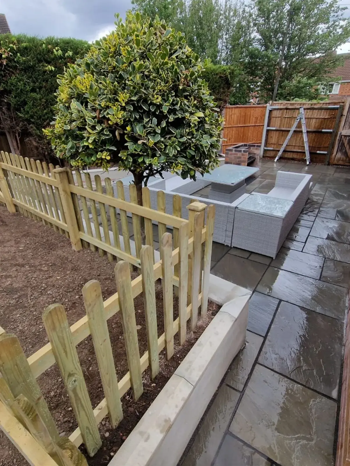 Timber picket fence beside a sandstone patio in a Solihull garden