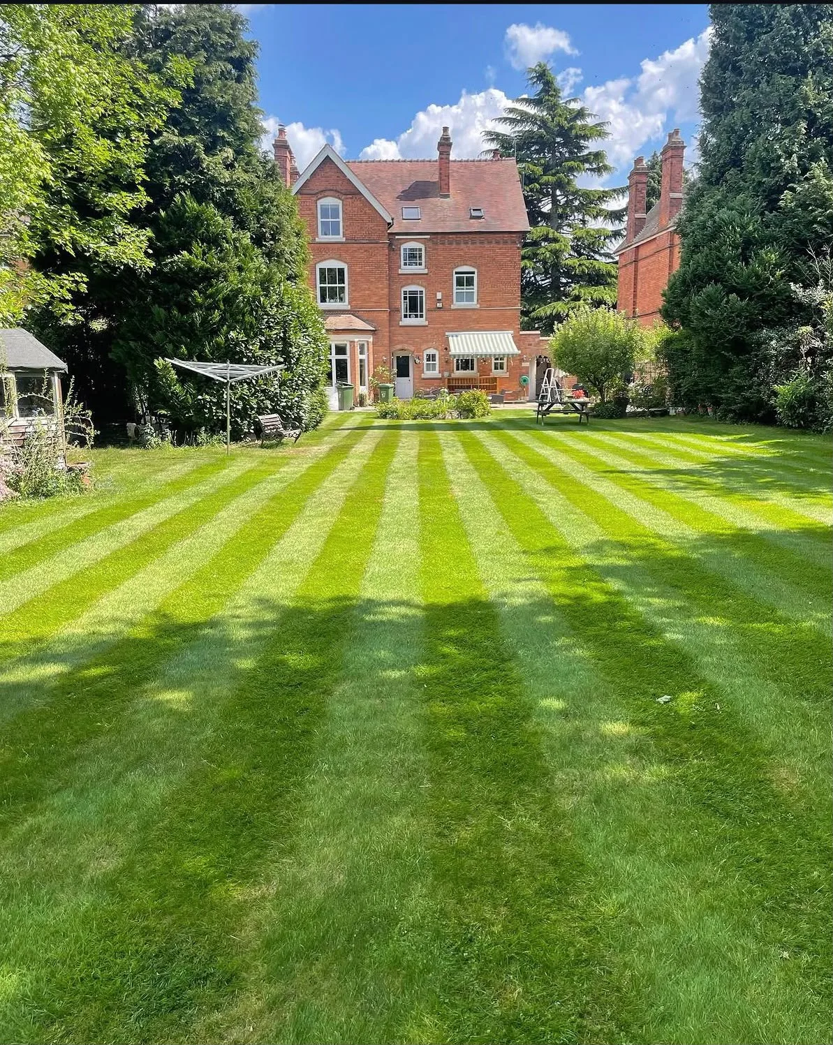 Freshly striped lawn in front of a large Victorian house in Solihull