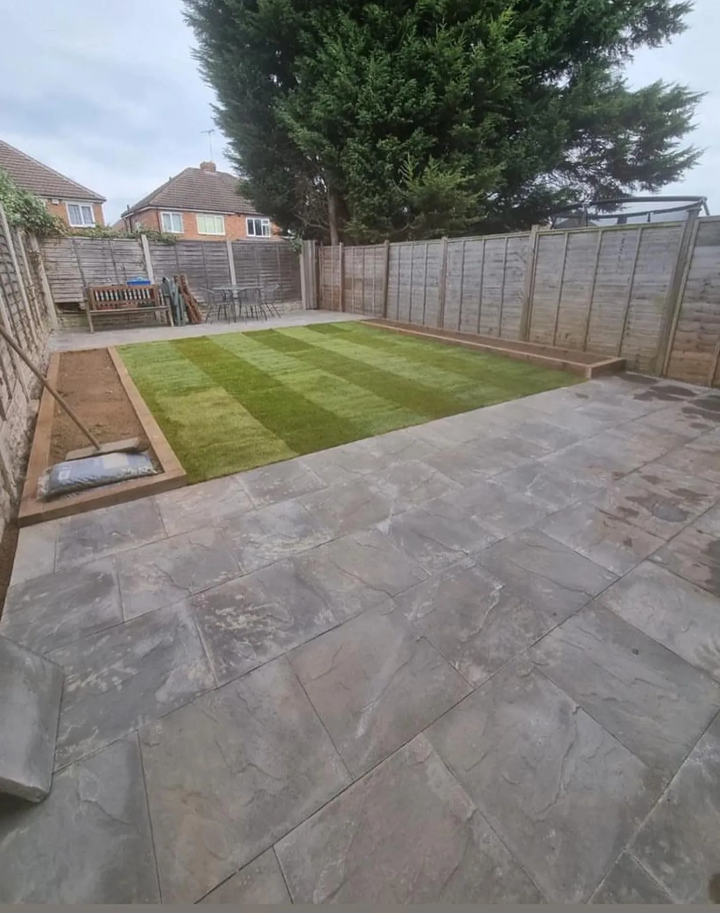 Freshly laid striped turf lawn beyond a new patio in Solihull